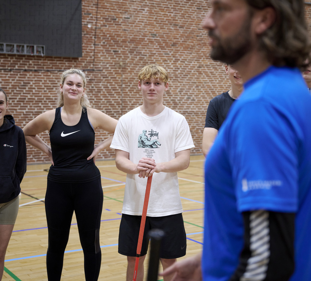 Elev står i rundkreds omkring idrætslæreren 