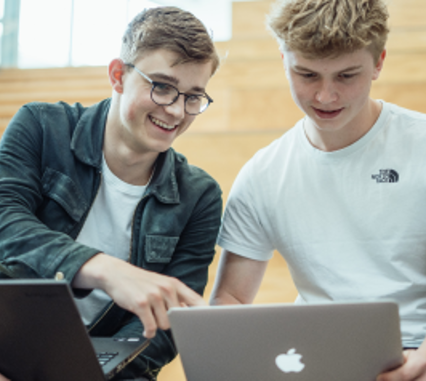 To elever arbejder sammen på computere