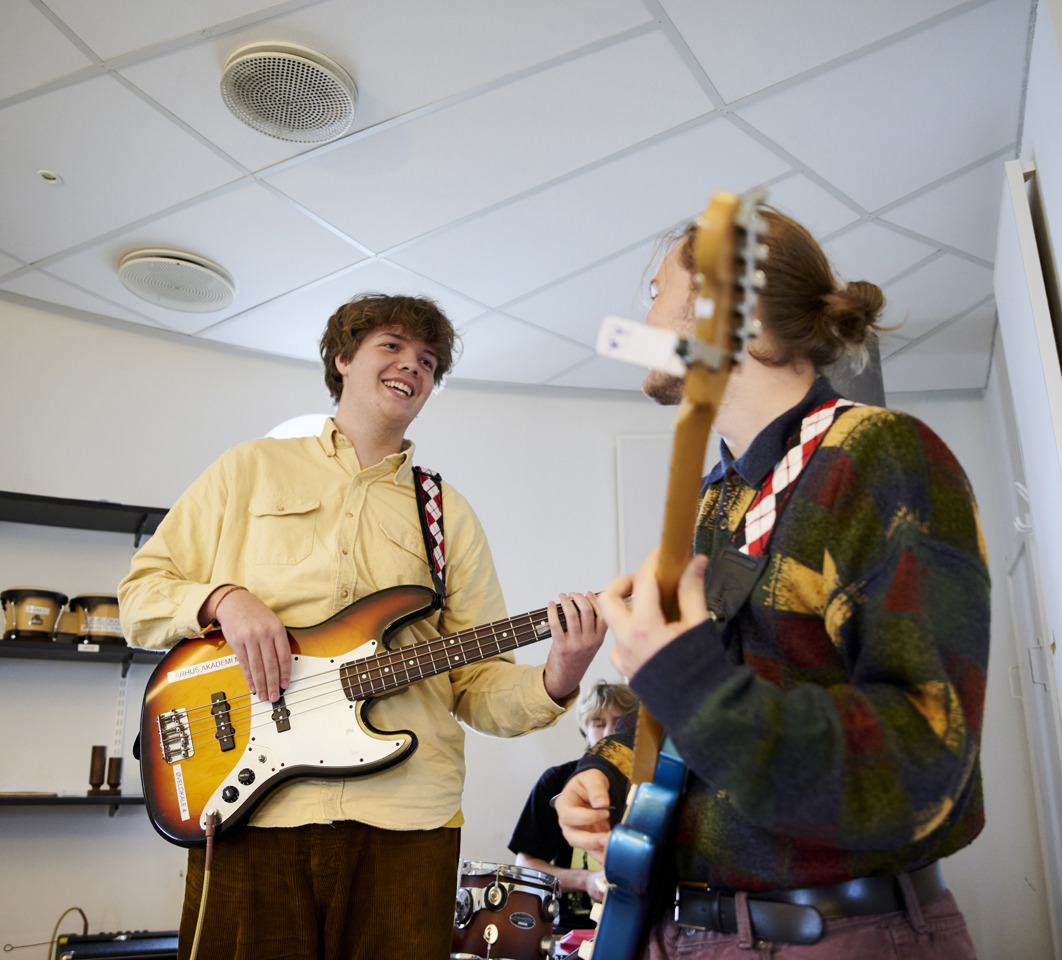 Glade musik studerende spiller på bas og guitar
