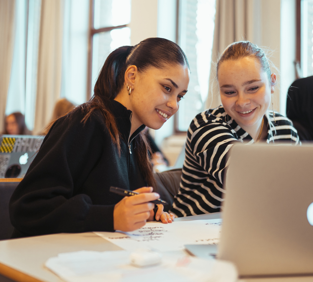 To smilende elever arbejeder sammen på en computer