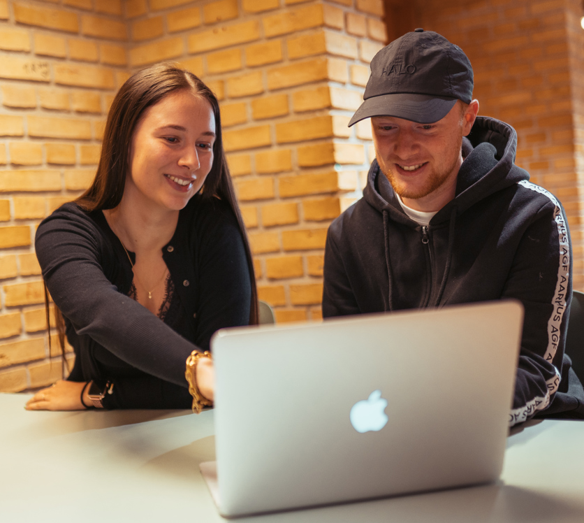 To glade elever arbejder sammen på en computer