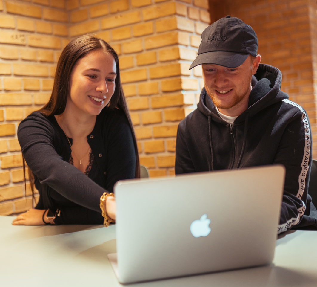 To glade elever arbejder sammen på en computer